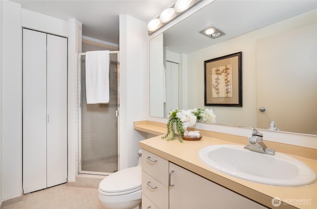 bathroom featuring vanity, a shower stall, toilet, and tile patterned flooring