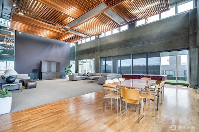 dining space with wood finished floors and a towering ceiling