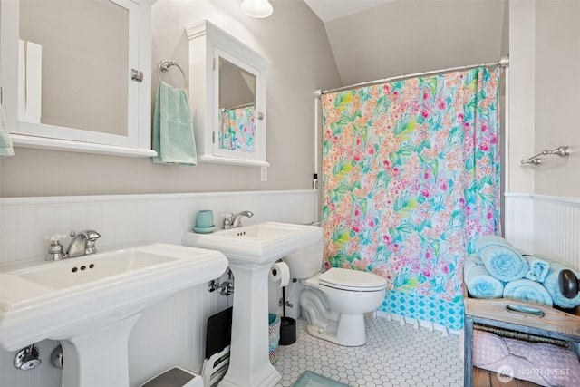 221 Meriweather St, Pacific Beach, WA 98571 - bathroom featuring toilet, a shower with shower curtain, wainscoting, tile patterned floors, and a sink
