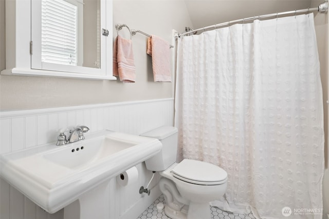 221 Meriweather St, Pacific Beach, WA 98571 - bathroom featuring tile patterned floors, a wainscoted wall, toilet, a shower with curtain, and a sink