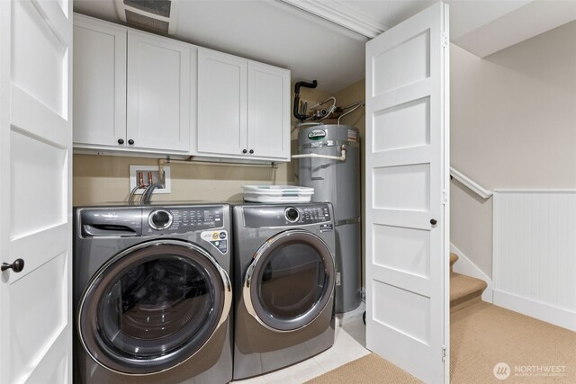 221 Meriweather St, Pacific Beach, WA 98571 - clothes washing area with a wainscoted wall, strapped water heater, cabinet space, separate washer and dryer, and tile patterned flooring