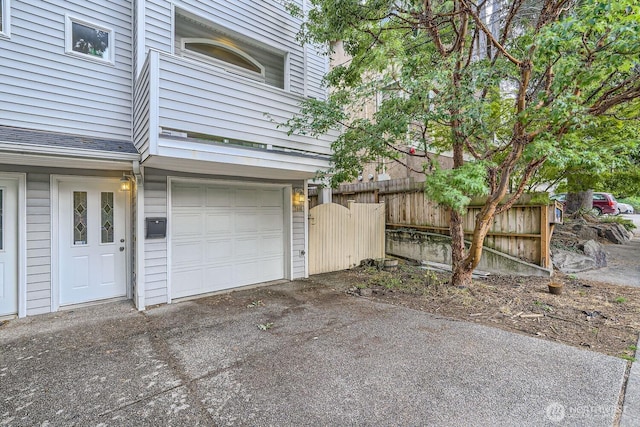 garage featuring driveway and fence