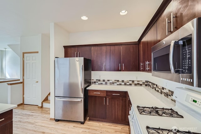 kitchen with appliances with stainless steel finishes, light countertops, and light wood-style floors