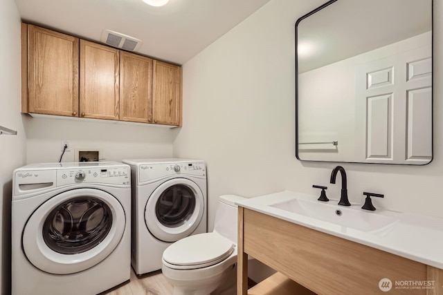 laundry room with visible vents, independent washer and dryer, and a sink