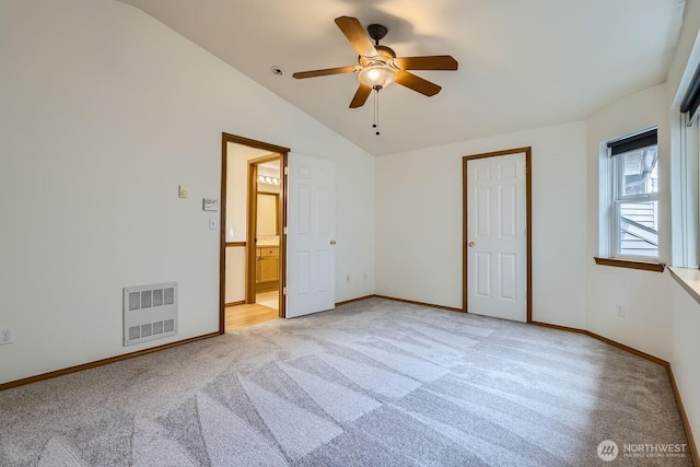 unfurnished bedroom with baseboards, visible vents, ensuite bath, vaulted ceiling, and light carpet