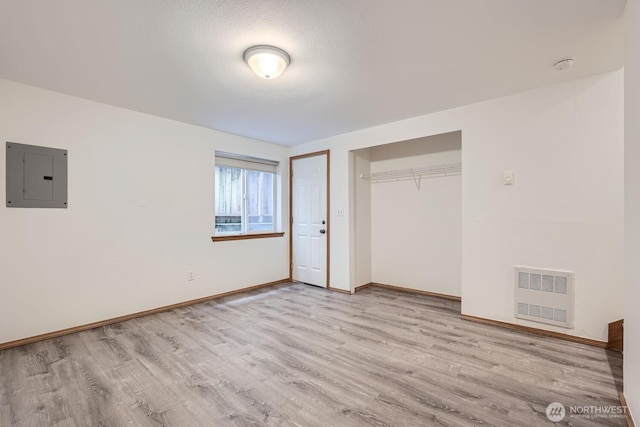 unfurnished bedroom with wood finished floors, visible vents, baseboards, electric panel, and a closet