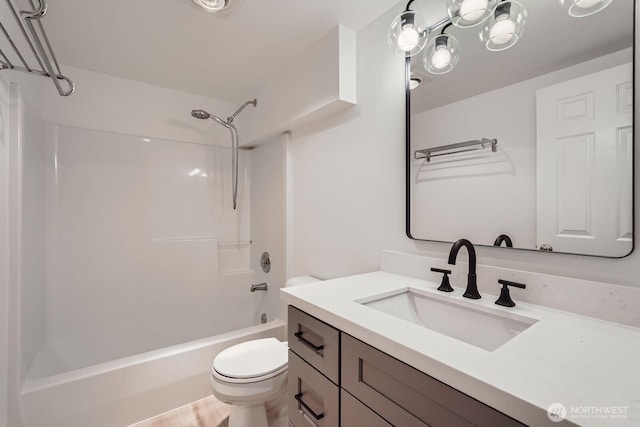 bathroom featuring toilet, vanity, and shower / tub combination