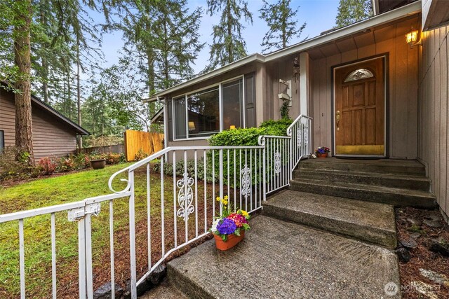 entrance to property with a yard and fence