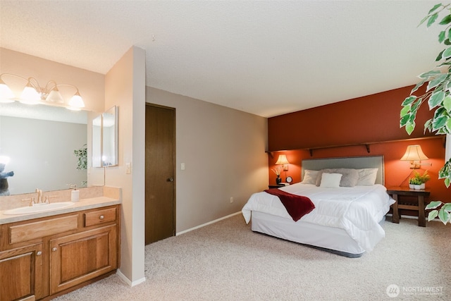 bedroom featuring a sink, baseboards, and light carpet