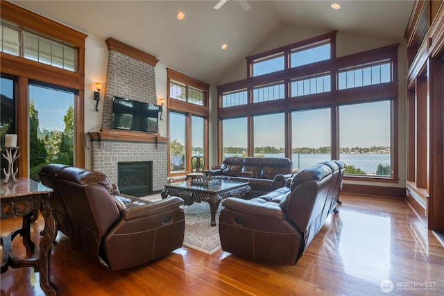 living area featuring recessed lighting, high vaulted ceiling, wood finished floors, and a fireplace