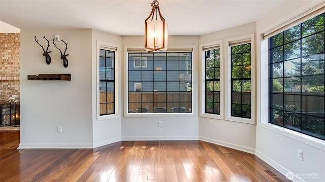 unfurnished dining area featuring visible vents, wood finished floors, and baseboards