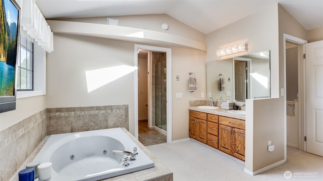 full bath with double vanity, vaulted ceiling, a jetted tub, and a sink