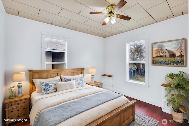 bedroom with ceiling fan, baseboards, and wood finished floors