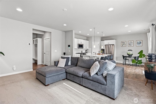 living area featuring recessed lighting, baseboards, and carpet