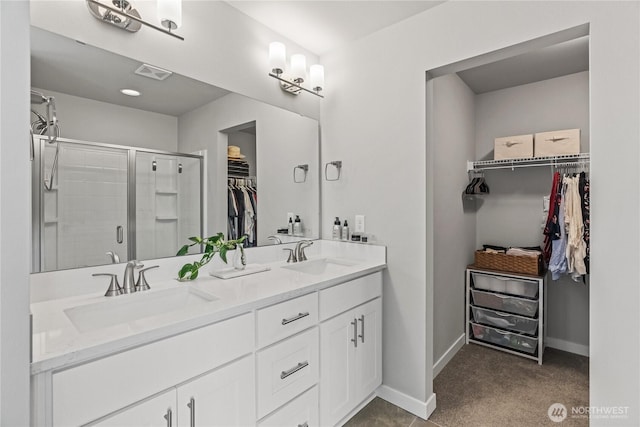 full bathroom with a shower stall, double vanity, visible vents, and a sink