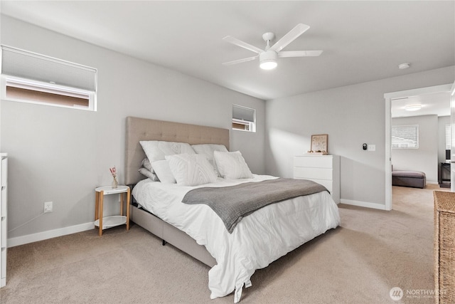 carpeted bedroom featuring multiple windows and baseboards