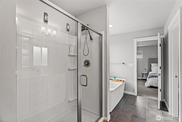 ensuite bathroom with a freestanding tub, baseboards, a stall shower, and ensuite bathroom