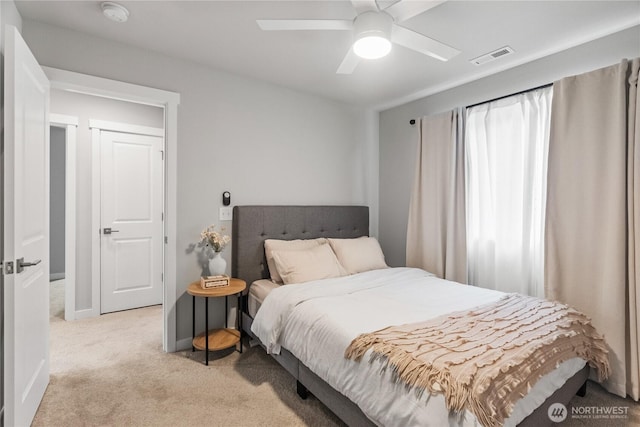 bedroom featuring ceiling fan, baseboards, visible vents, and light carpet