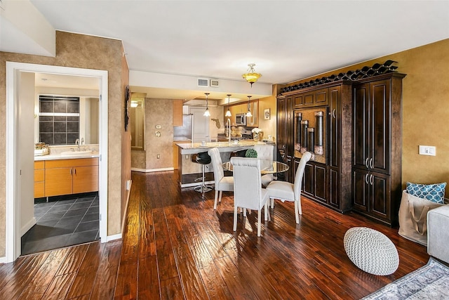 dining area with visible vents, baseboards, and dark wood-style flooring