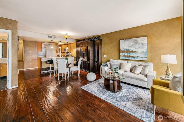 living room with dark wood-style floors and visible vents