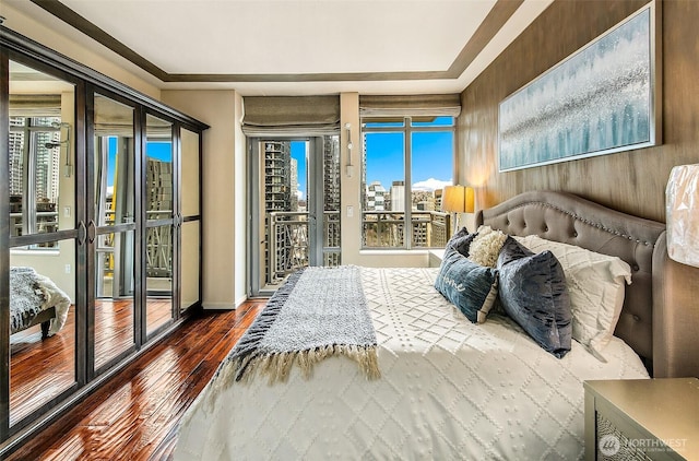 bedroom with hardwood / wood-style floors and access to outside