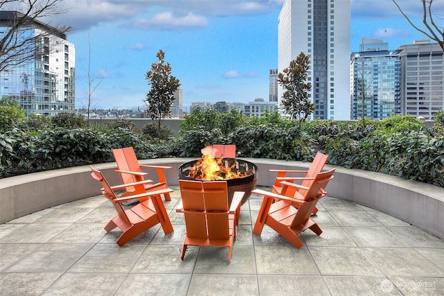 view of patio with a city view and a fire pit