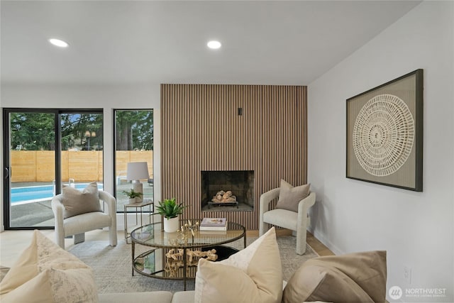 living area with a fireplace, recessed lighting, and baseboards