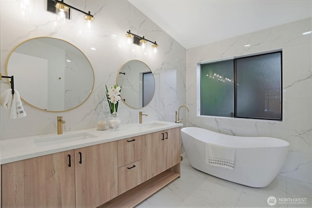 bathroom featuring double vanity, stone wall, marble finish floor, and a sink