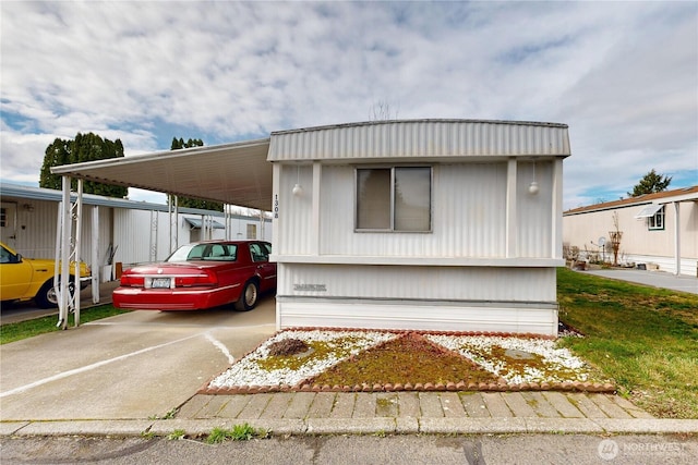 manufactured / mobile home featuring an attached carport and driveway