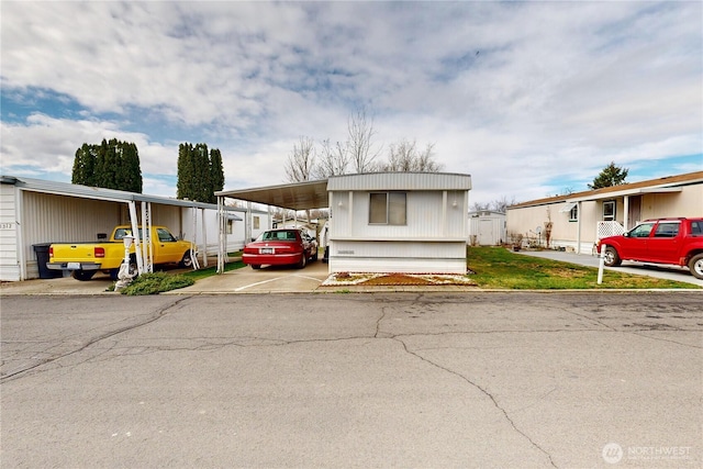 manufactured / mobile home featuring an attached carport and driveway