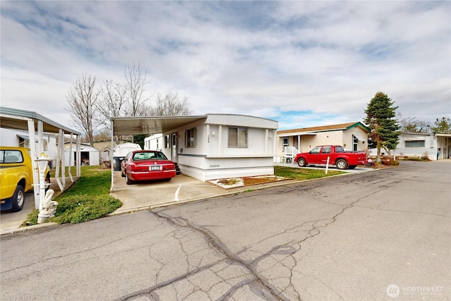 manufactured / mobile home featuring an attached carport and concrete driveway