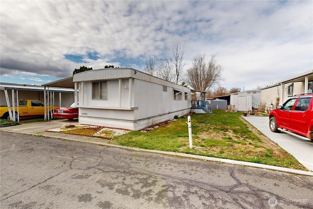 view of side of property with a yard, an outbuilding, and a shed