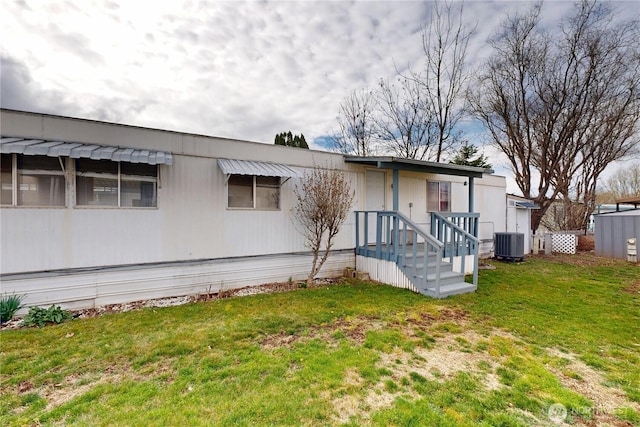 rear view of property with a lawn and central AC