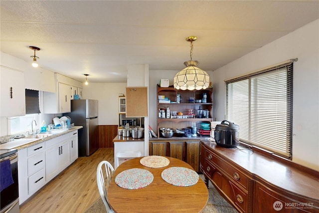 kitchen featuring white cabinetry, light wood-type flooring, freestanding refrigerator, and electric range oven