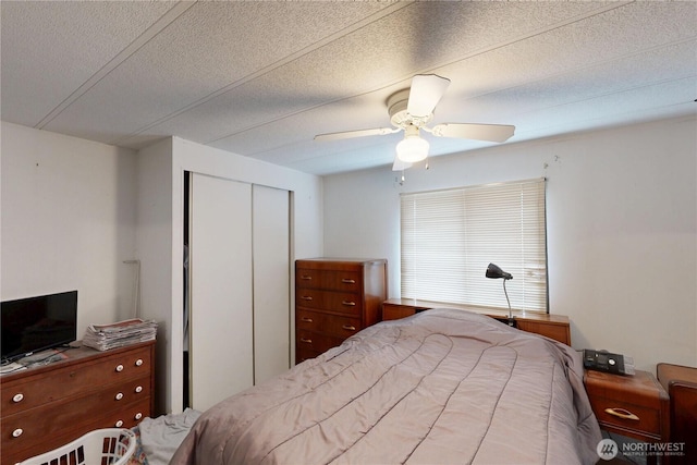 bedroom featuring a closet, a textured ceiling, and ceiling fan