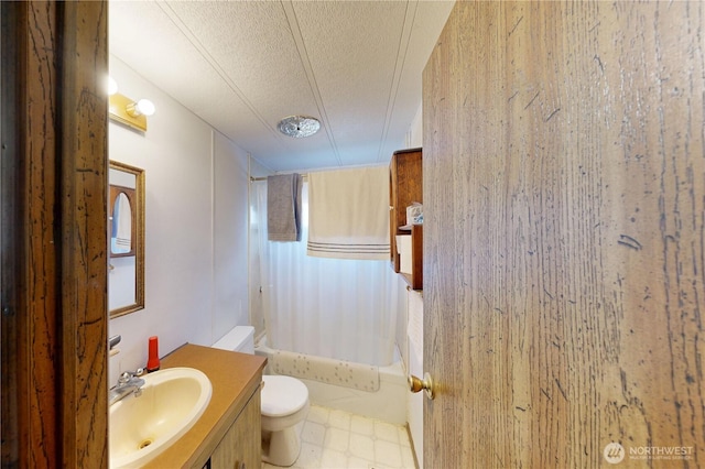 full bathroom with vanity, shower / bath combo with shower curtain, a textured ceiling, tile patterned floors, and toilet