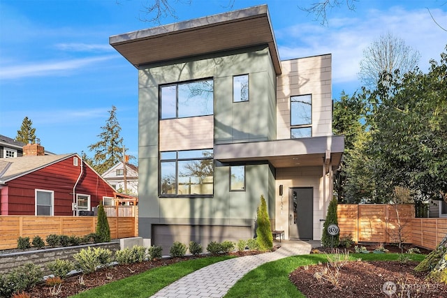 contemporary home with stucco siding and fence