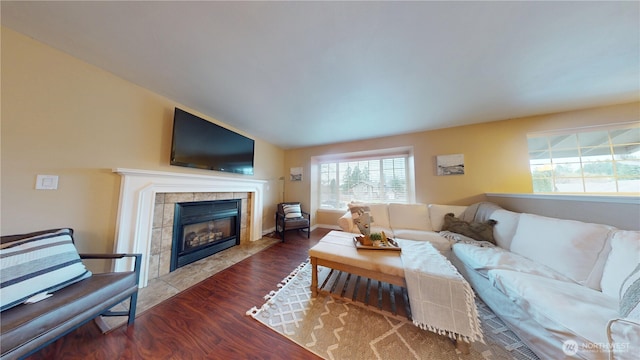 living room with wood finished floors and a tile fireplace