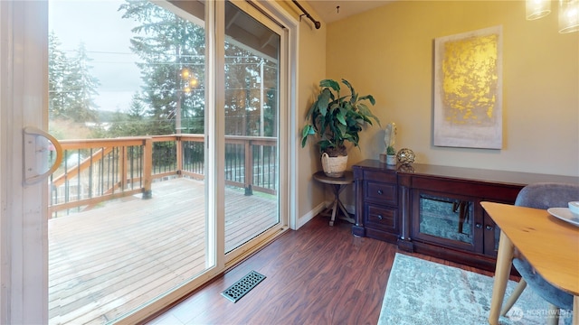 doorway to outside featuring wood finished floors, visible vents, and baseboards