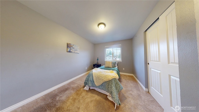 bedroom featuring light colored carpet and baseboards