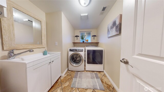 laundry area featuring visible vents, a sink, cabinet space, separate washer and dryer, and baseboards