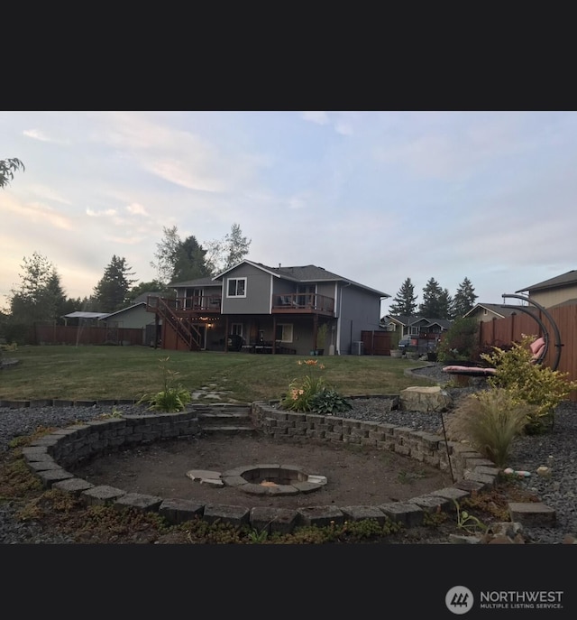 exterior space featuring fence, stairway, an outdoor fire pit, a yard, and a deck