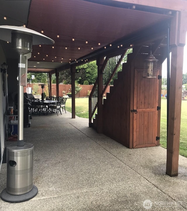 view of patio with stairway, outdoor dining area, and fence