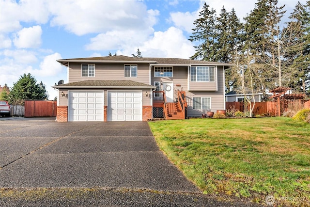 bi-level home featuring brick siding, a front yard, driveway, and fence