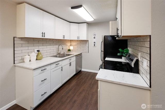 kitchen with dark wood-style flooring, appliances with stainless steel finishes, decorative backsplash, and a sink