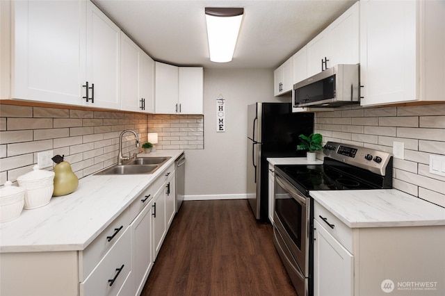 kitchen with white cabinets, appliances with stainless steel finishes, dark wood-type flooring, and a sink