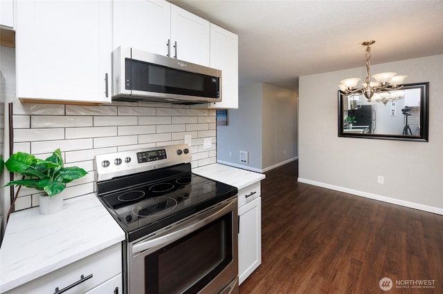 kitchen featuring dark wood-style floors, white cabinetry, appliances with stainless steel finishes, decorative backsplash, and light stone countertops