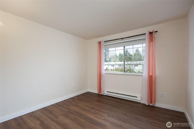 spare room featuring dark wood-style floors, baseboards, and baseboard heating