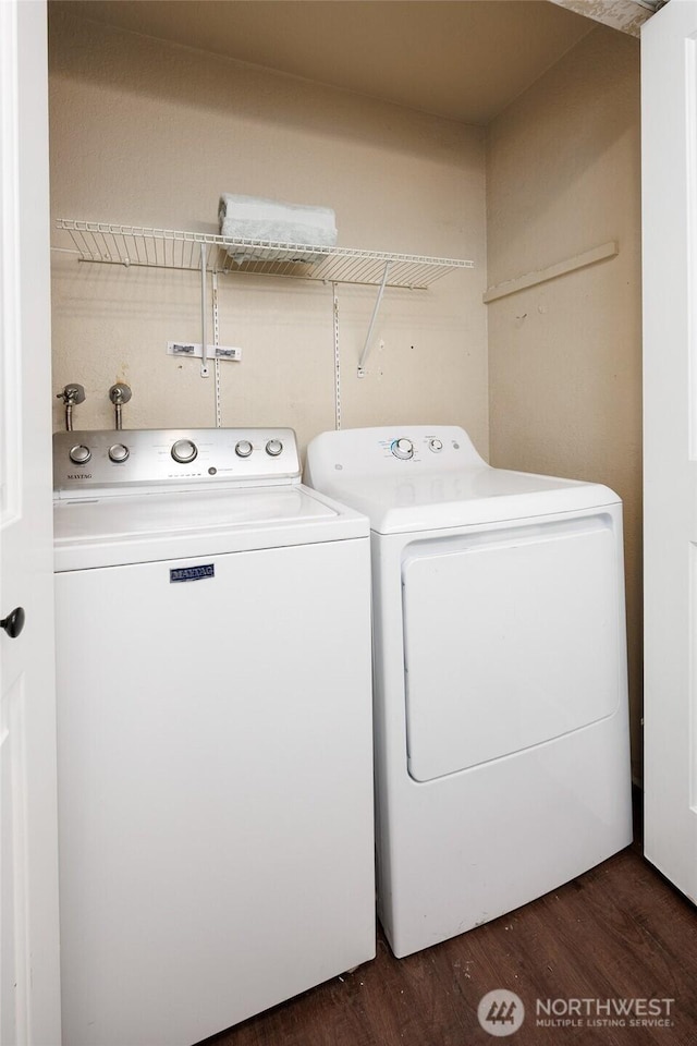 clothes washing area with washer and clothes dryer, laundry area, and dark wood-style floors