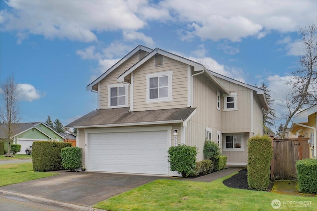 view of front of house with a front yard, fence, driveway, an attached garage, and a shingled roof